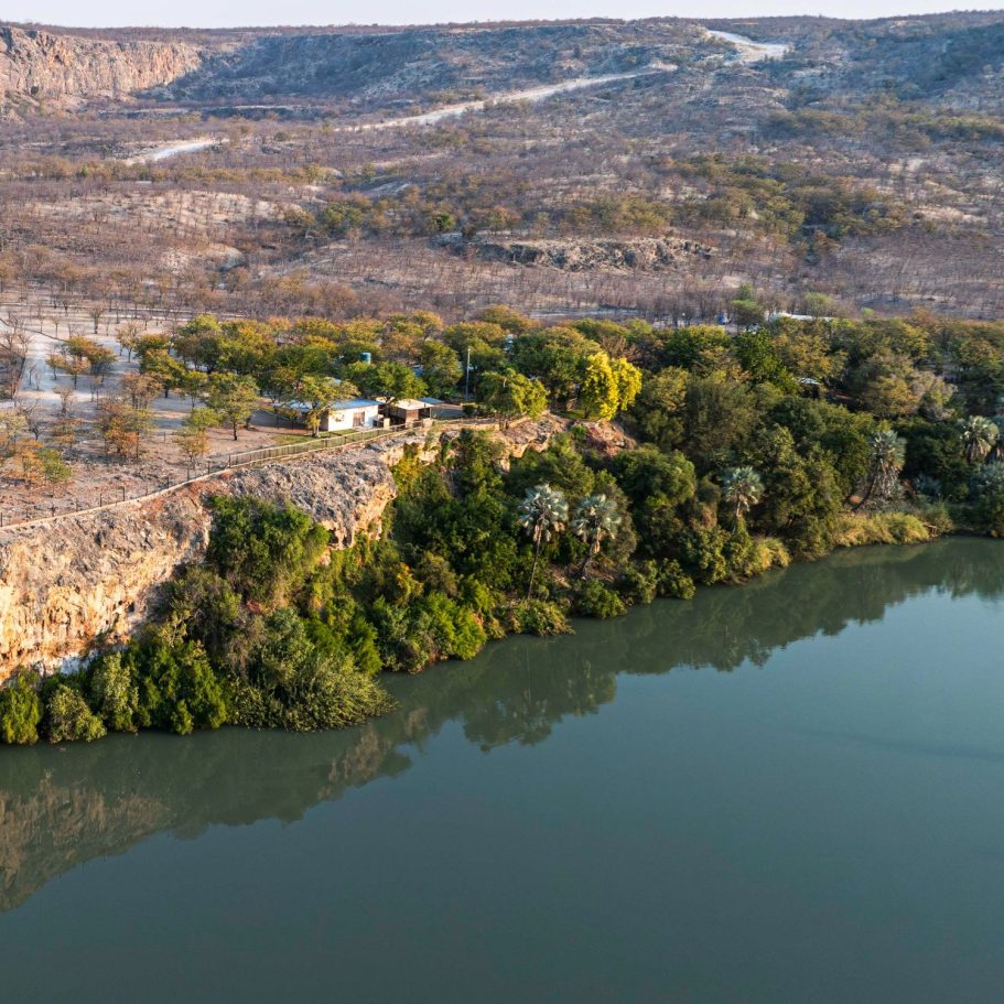 Blick auf einen ruhigen Fluss an einer bewaldeten Uferlinie.